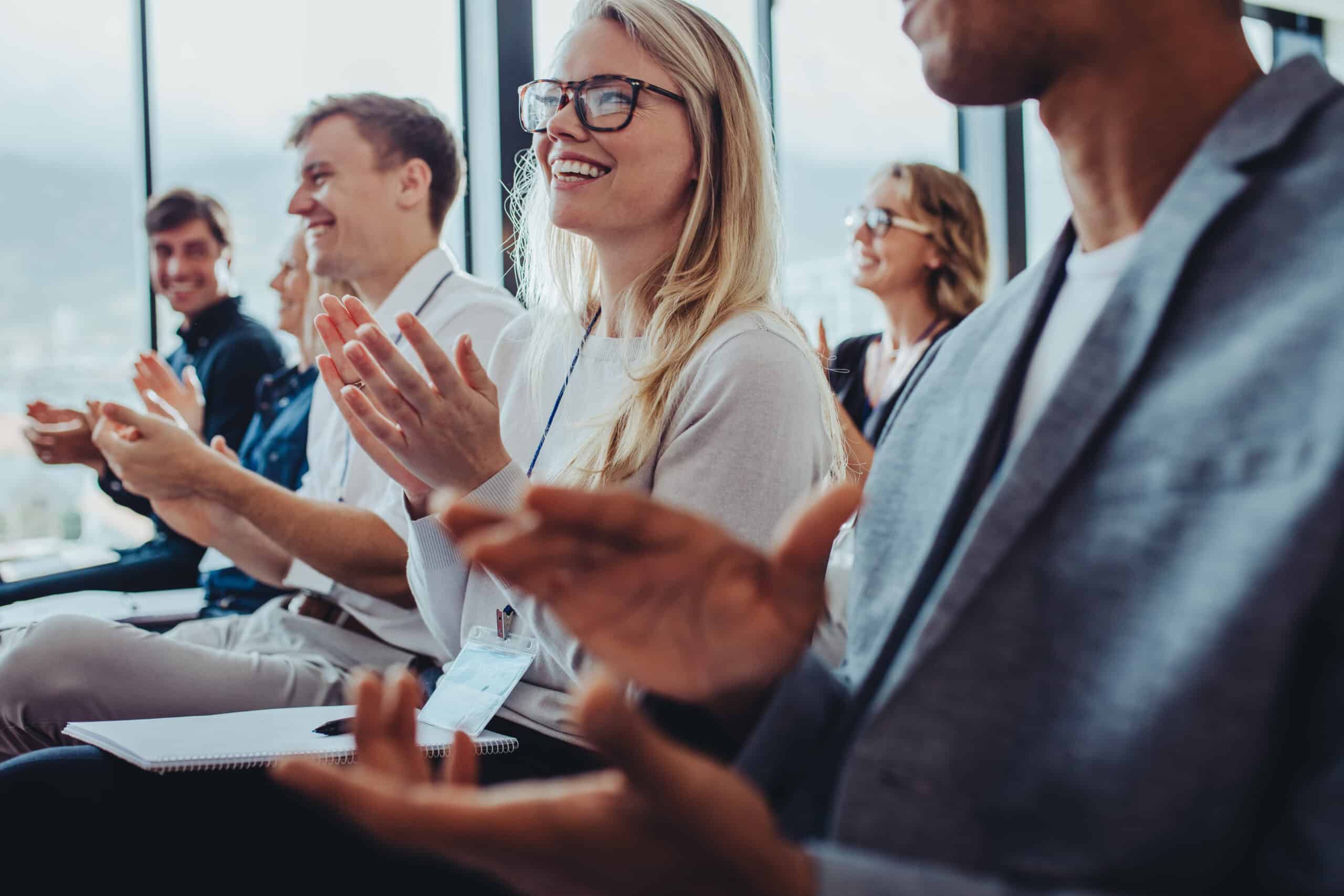 Team of businesspeople clapping hands while having a conference. Business professionals applauding at a seminar.